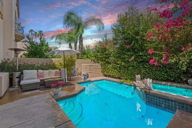 a view of a backyard with couches table and chairs and potted plants