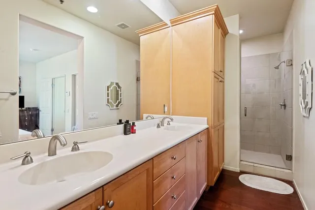 a bathroom with a double vanity sink mirror and shower