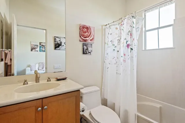 a bathroom with a sink a toilet and shower curtain