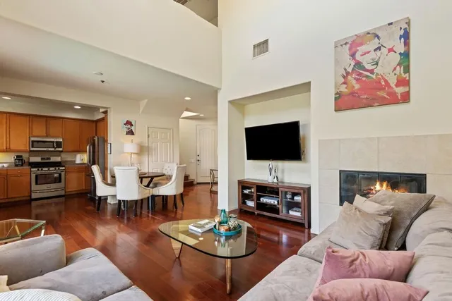 a living room with furniture kitchen view and a flat screen tv