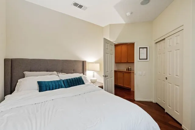 a bedroom with a large bed and wooden floor