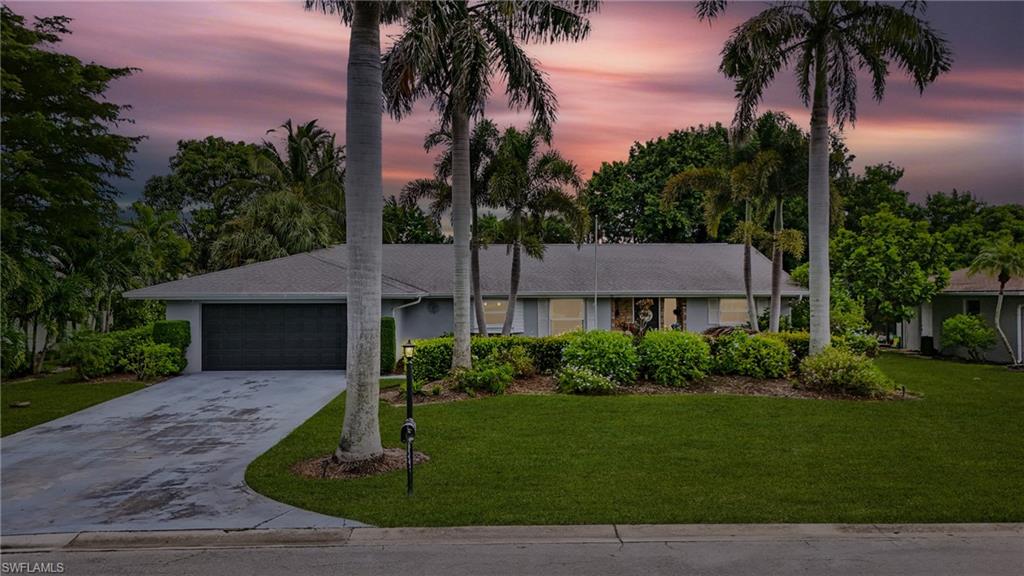 249 Pebble Beach Circle Naples, FL 34113 - Photo 1 of 45 Ranch-style home featuring concrete driveway, a front lawn, and an attached garage
