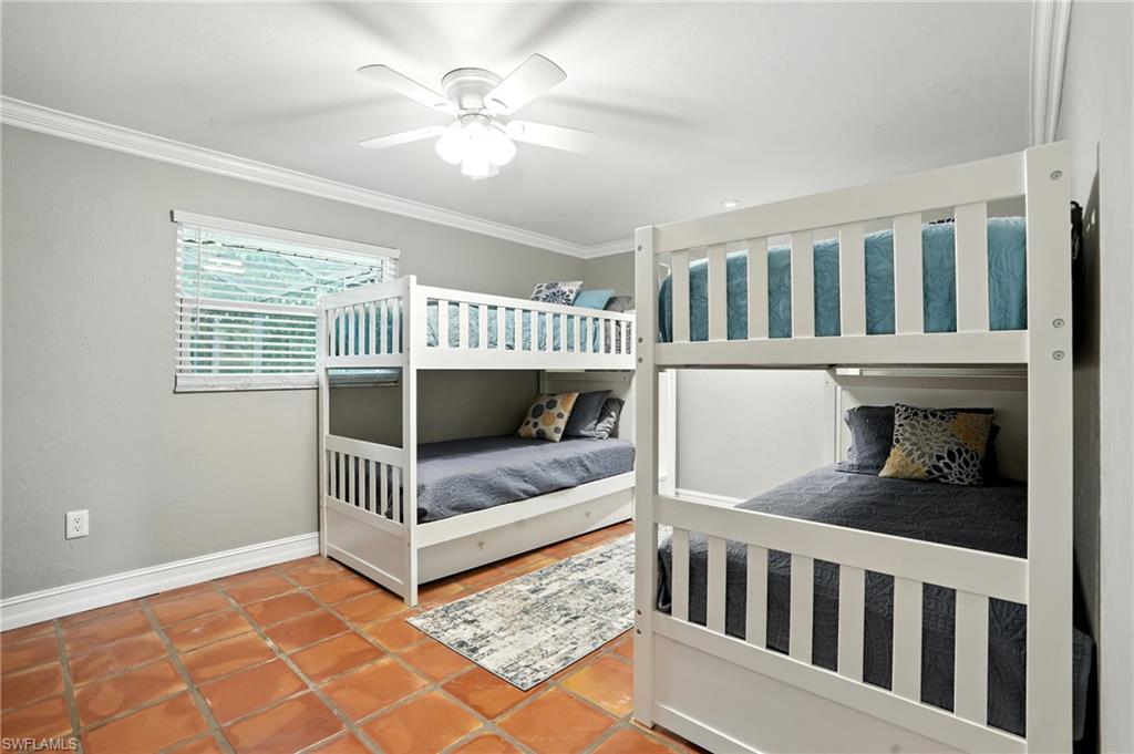249 Pebble Beach Circle Naples, FL 34113 - Photo 29 of 45 Tiled bedroom with crown molding and a ceiling fan