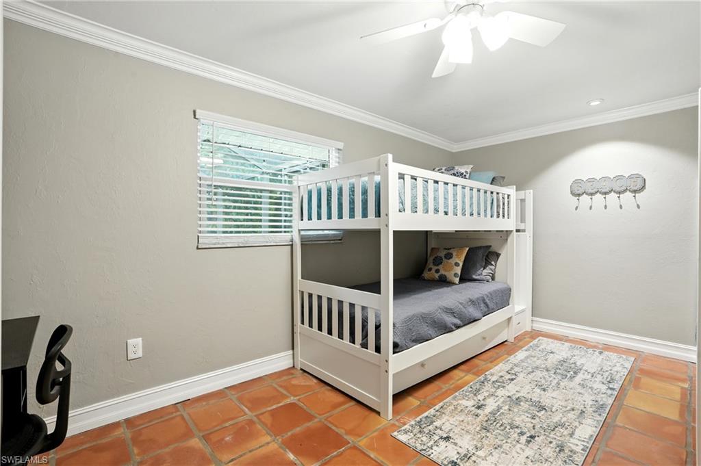 249 Pebble Beach Circle Naples, FL 34113 - Photo 30 of 45 Tiled bedroom featuring crown molding and a ceiling fan