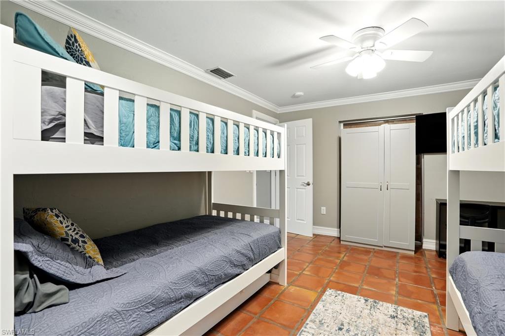 249 Pebble Beach Circle Naples, FL 34113 - Photo 31 of 45 Bedroom featuring ornamental molding, a ceiling fan, a closet, and light tile patterned floors
