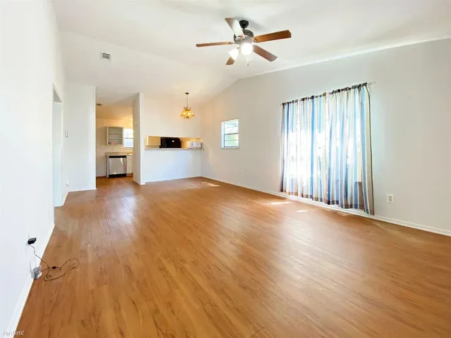 a view of a livingroom with wooden floor and a ceiling fan