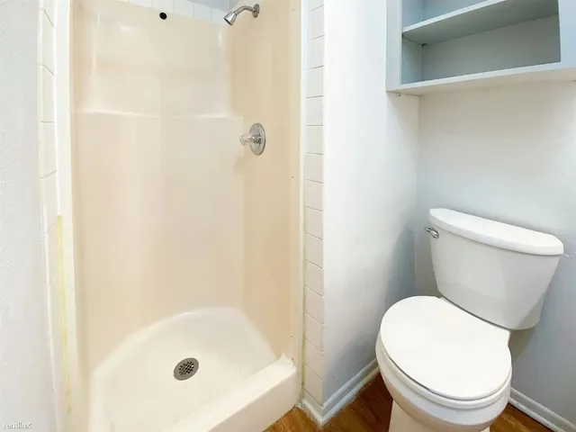 a white toilet sitting next to a bath tub
