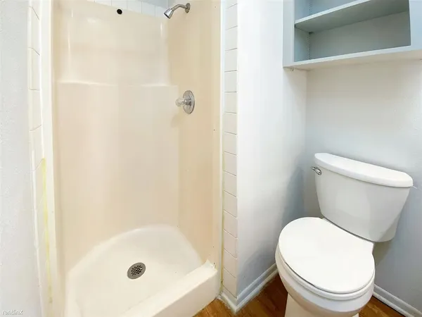 a white toilet sitting next to a bath tub
