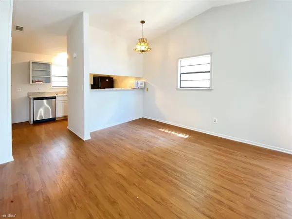 a view of a livingroom with wooden floor and a window