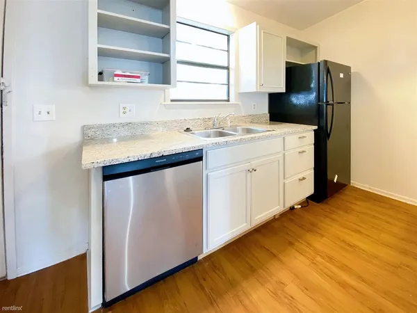 a kitchen with a sink cabinets and wooden floor