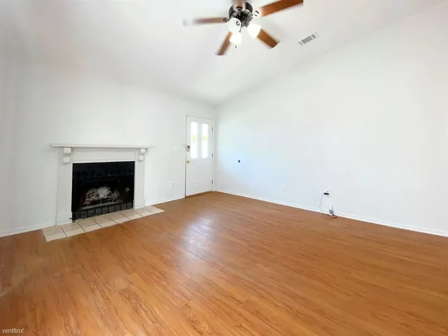 a view of empty room with wooden floor and fireplace