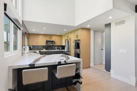 a kitchen with a dining table chairs and refrigerator