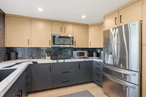 a kitchen with a sink a refrigerator and cabinets