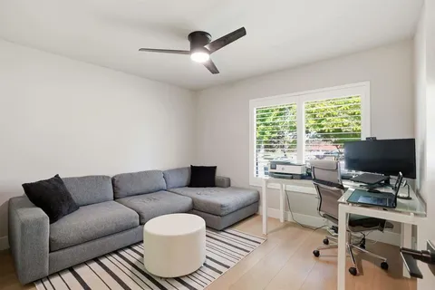 a living room with furniture a ceiling fan and a window