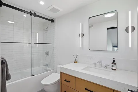 a bathroom with a sink toilet a mirror and shower