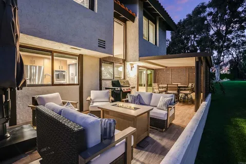 a view of a patio with couches chairs dining table and chairs with wooden floor