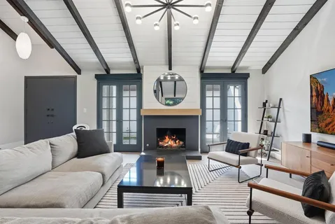 a living room with furniture a fireplace and a chandelier