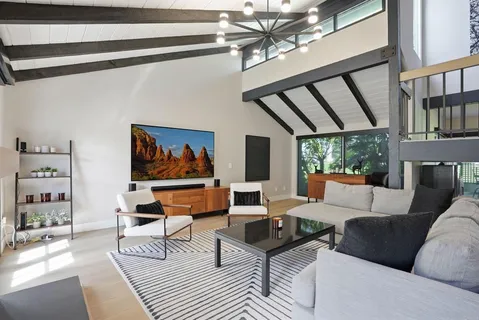 a living room with furniture a rug and a wall painting