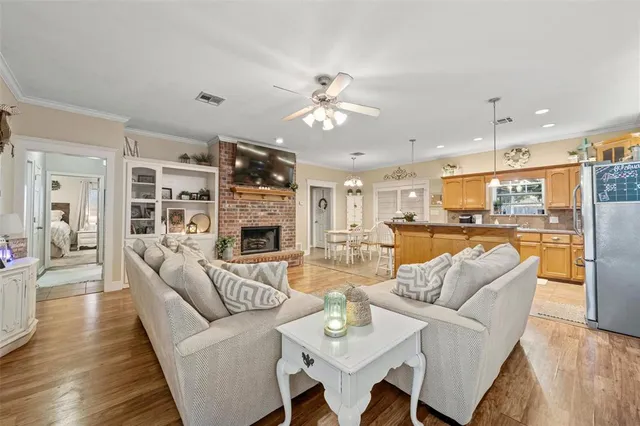 a living room with furniture kitchen view and a chandelier