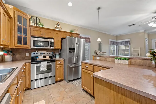 a kitchen with stainless steel appliances granite countertop a sink a stove and a refrigerator