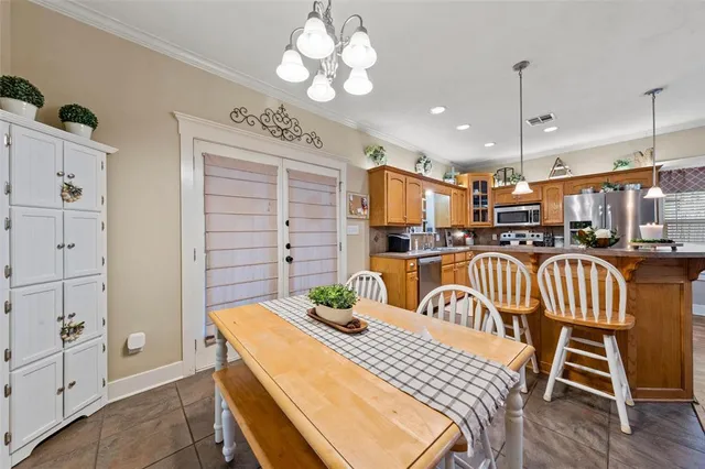 a kitchen with stainless steel appliances granite countertop a stove a kitchen island with chairs and cabinets