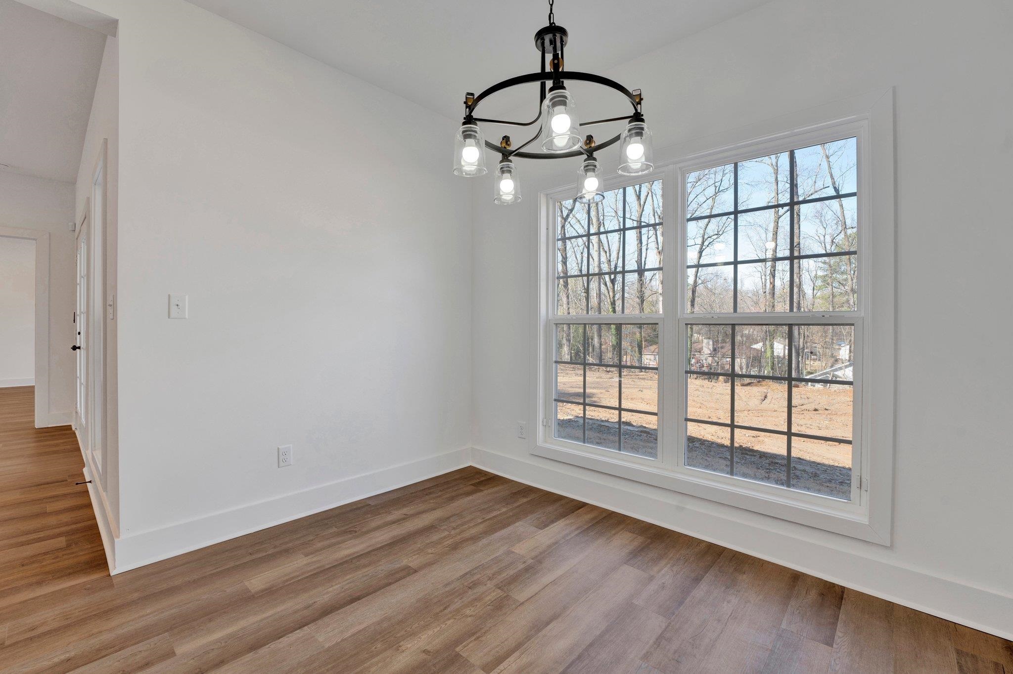 5702 Spring Lake Road Memphis, TN 38135 - Photo 18 of 38 a view of an empty room with wooden floor and a window