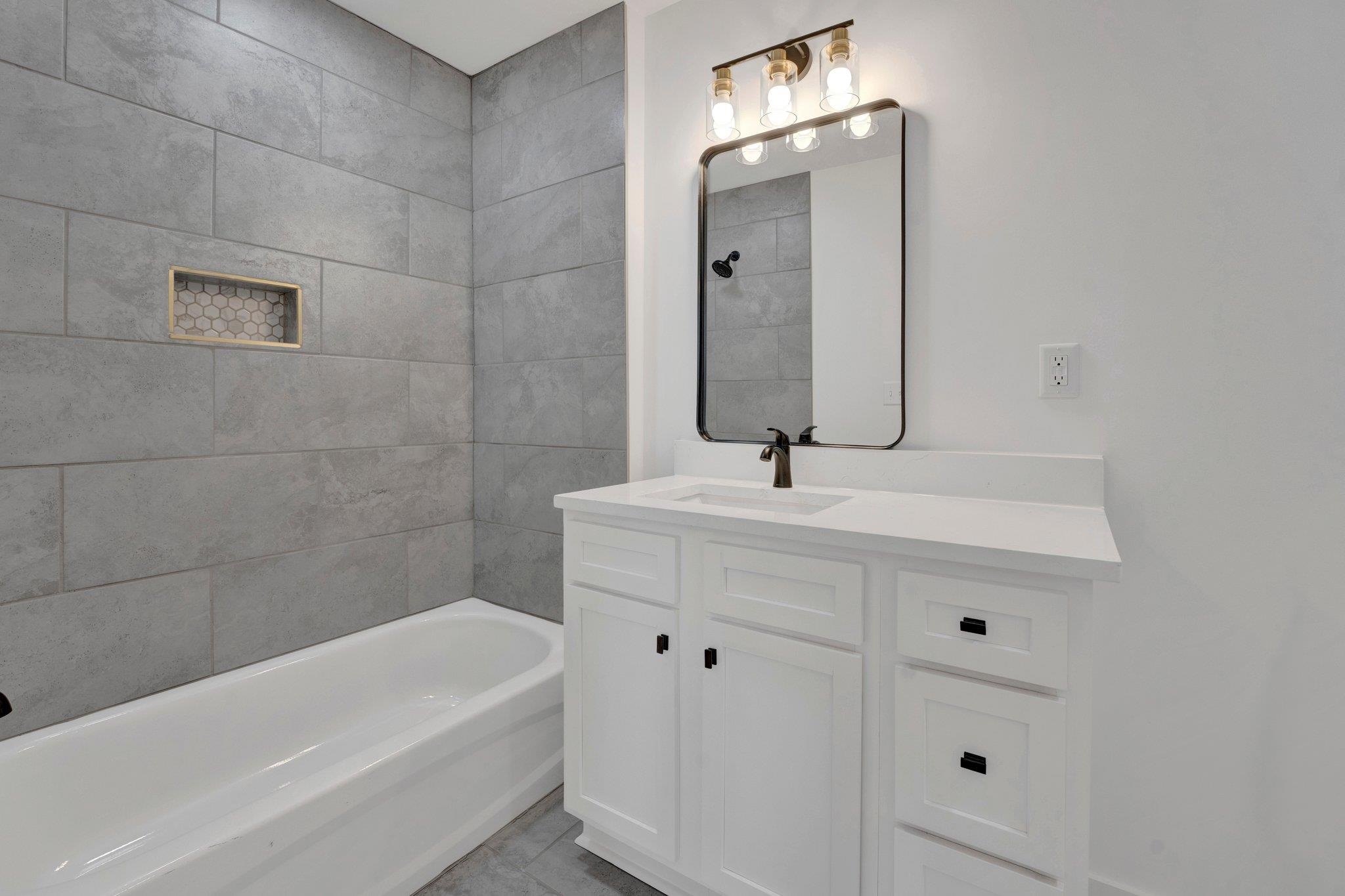 5702 Spring Lake Road Memphis, TN 38135 - Photo 31 of 38 a bathroom with a bathtub a sink a vanity and a window