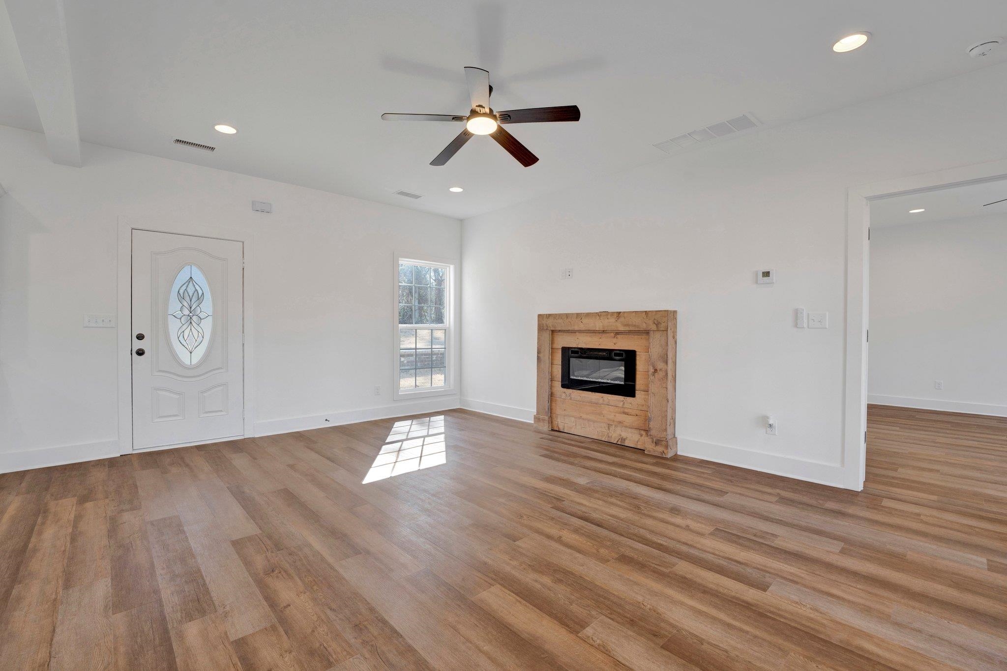 5702 Spring Lake Road Memphis, TN 38135 - Photo 6 of 38 an empty room with wooden floor a ceiling fan and windows