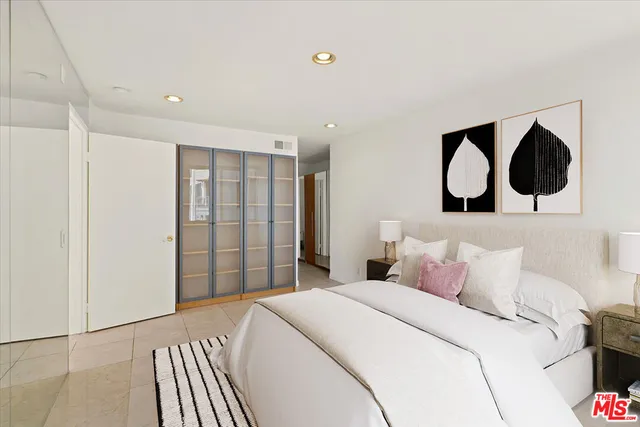 a bedroom with a large bed and a painting on the wall