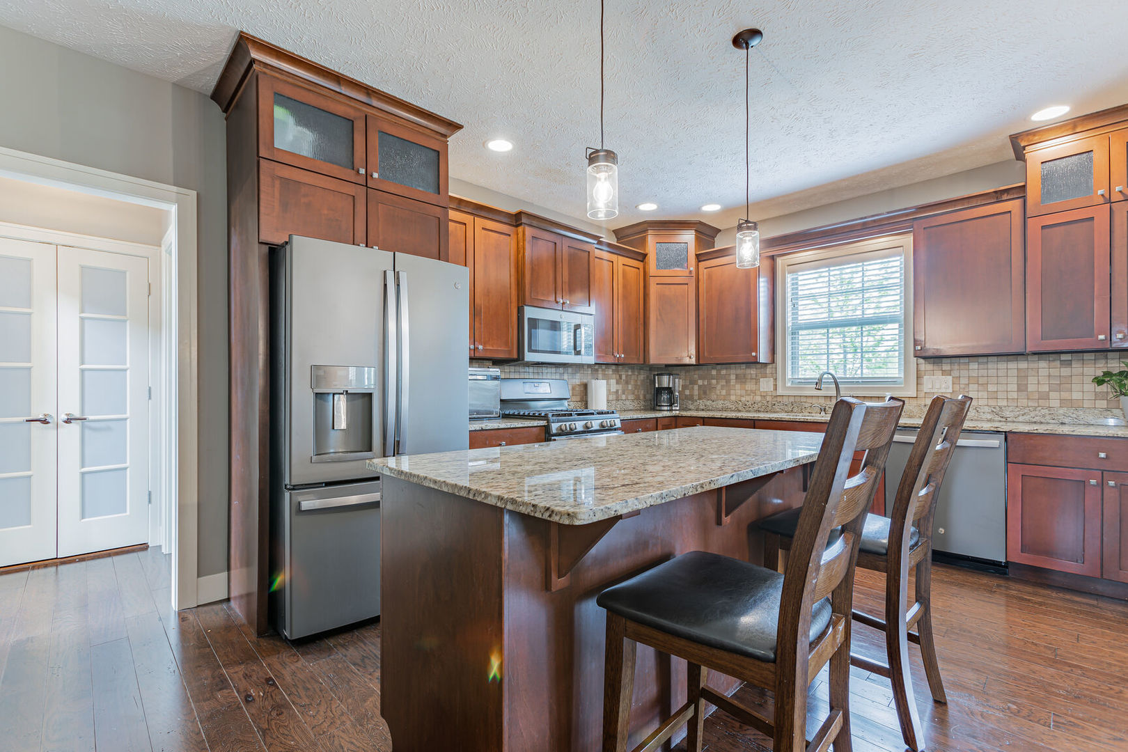 5 Fletcher Court Savoy, IL 61874 - Photo 2 of 48 a kitchen with stainless steel appliances granite countertop a refrigerator a sink dishwasher a stove and a dining table with wooden floor