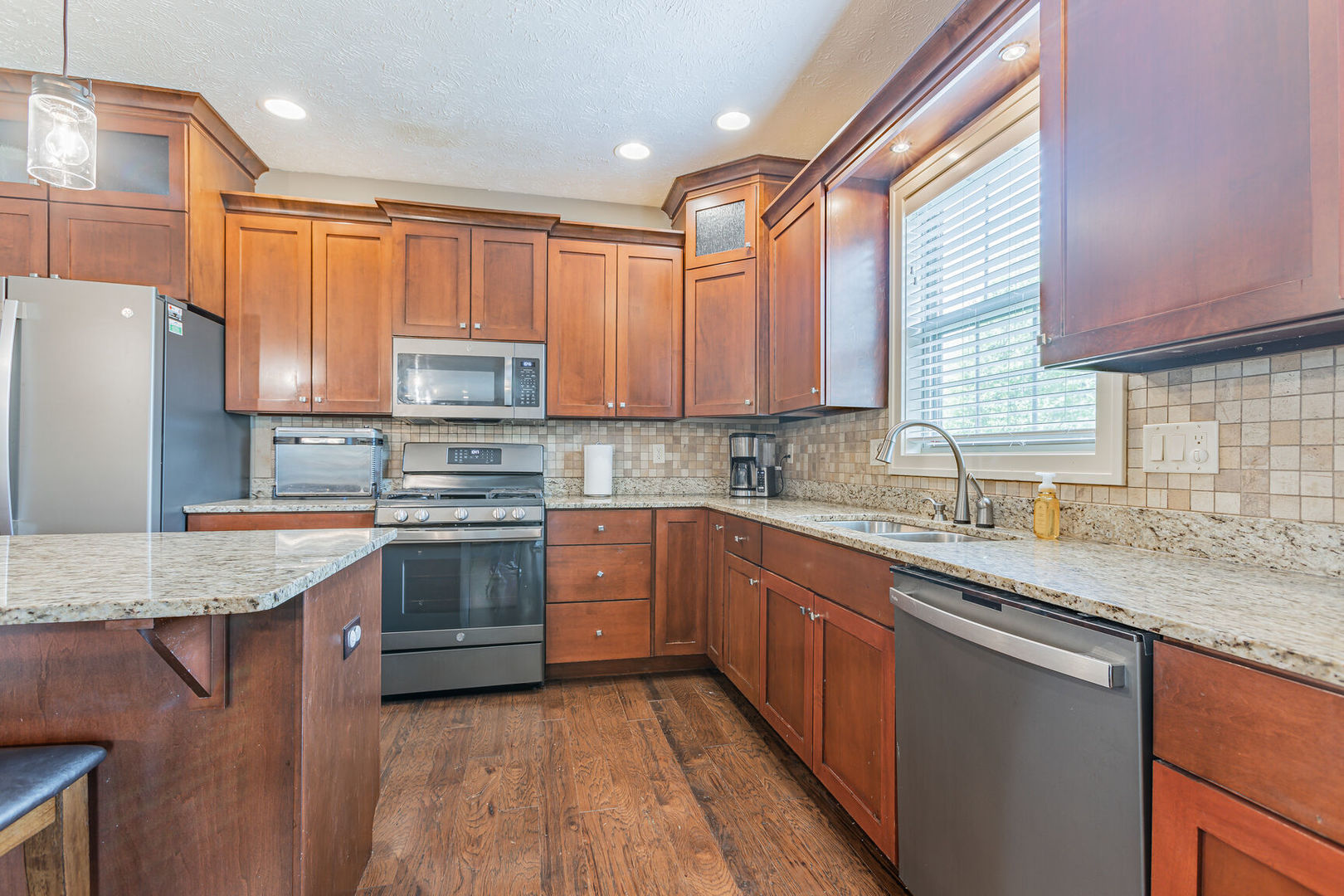 5 Fletcher Court Savoy, IL 61874 - Photo 7 of 48 a kitchen with stainless steel appliances granite countertop a stove a sink dishwasher a refrigerator and a oven with wooden floor