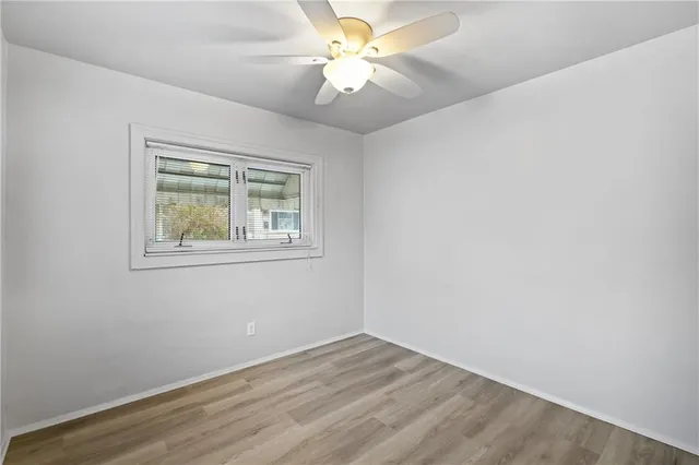 an empty room with a window and a fan