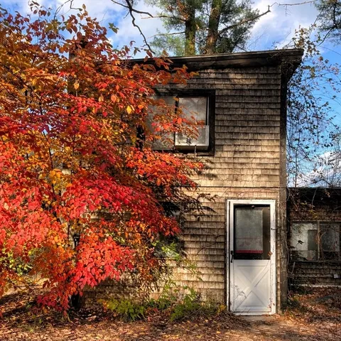 a front view of a house with a tree