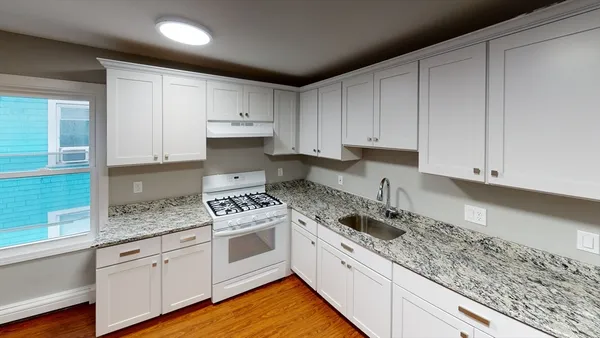 a kitchen with granite countertop white cabinets and white appliances