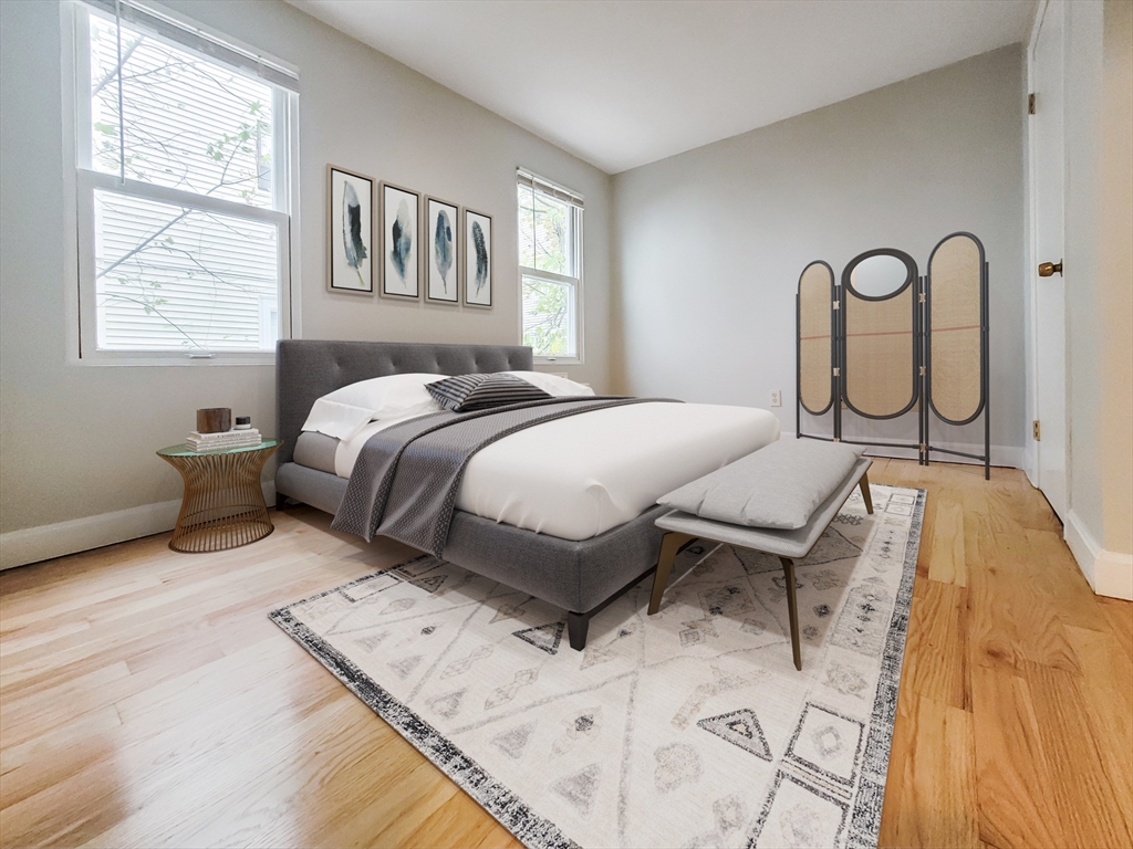 49 Rosedale Street, Unit 1 Boston, MA 02124 - Photo 6 of 8 a bedroom with a bed and dresser with wooden floor