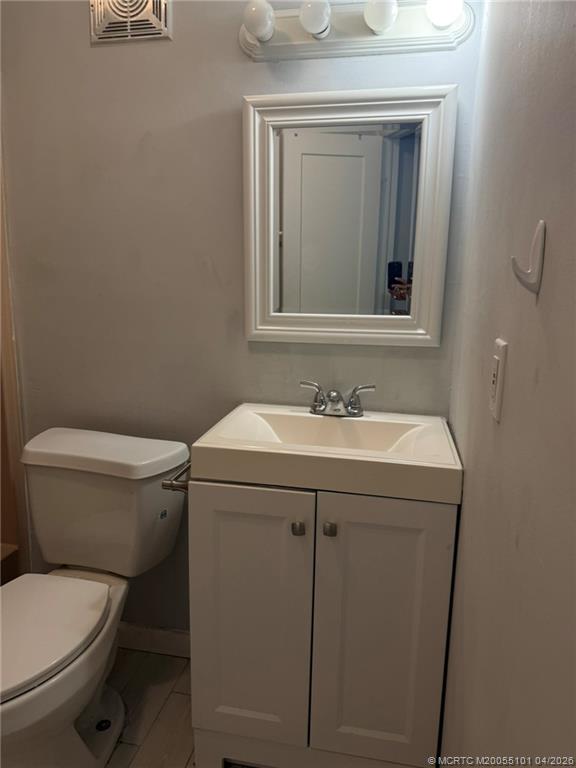 2124 Southeast Edler Drive Stuart, FL 34994 - Photo 14 of 16 a bathroom with a toilet sink and mirror
