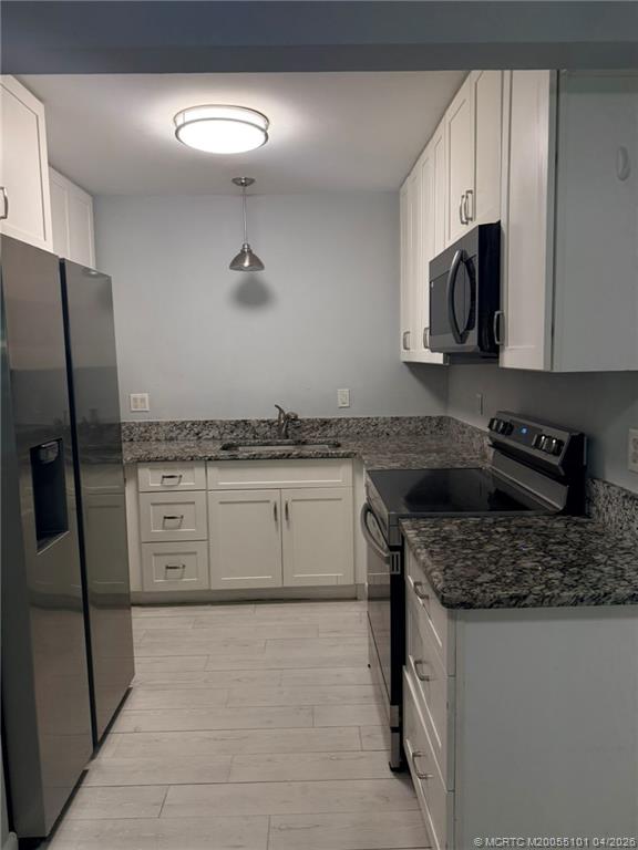 2124 Southeast Edler Drive Stuart, FL 34994 - Photo 3 of 16 a kitchen with stainless steel appliances granite countertop a stove a sink and a refrigerator