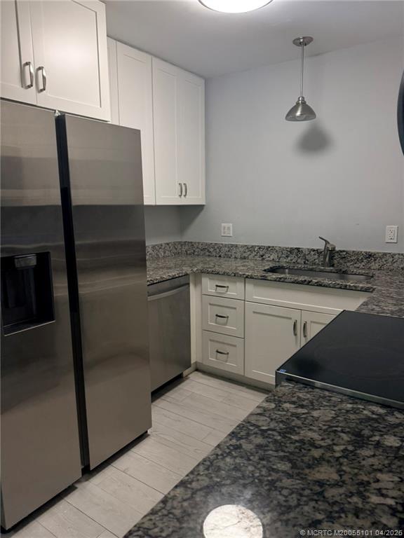 2124 Southeast Edler Drive Stuart, FL 34994 - Photo 4 of 16 a kitchen with stainless steel appliances granite countertop a refrigerator a stove and white cabinets
