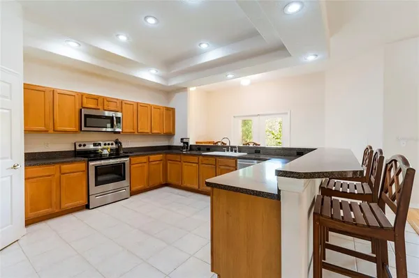 a kitchen with granite countertop stainless steel appliances a stove sink and microwave
