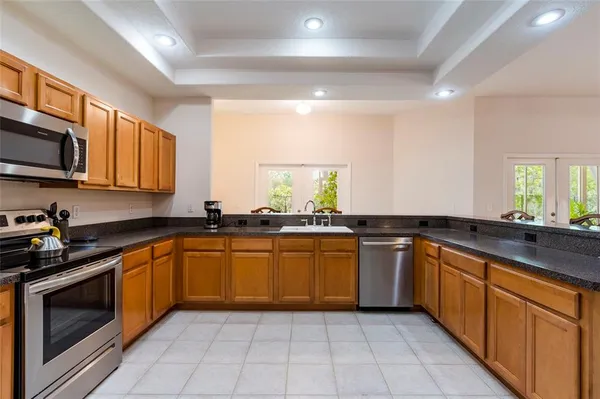 a kitchen with stainless steel appliances granite countertop a refrigerator a sink and dishwasher