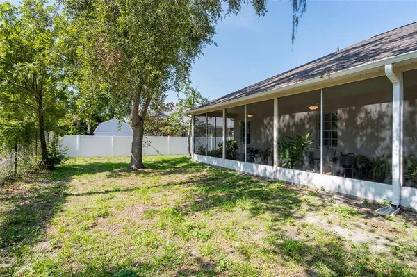 a view of a house with backyard and a tree