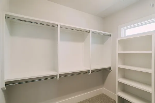 a room with walk in closet and empty racks