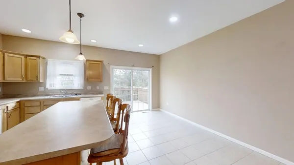 a kitchen with a table chairs and refrigerator