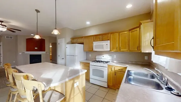 a kitchen with stainless steel appliances granite countertop a sink a stove and a wooden floors