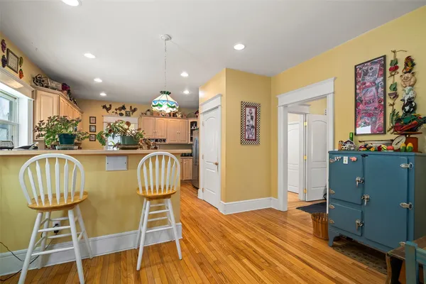 a dining room with furniture a chandelier and wooden floor