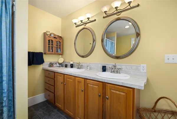 a bathroom with a granite countertop double vanity sink and a mirror