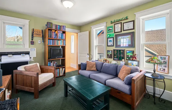 a living room with furniture a bookshelf and a large window