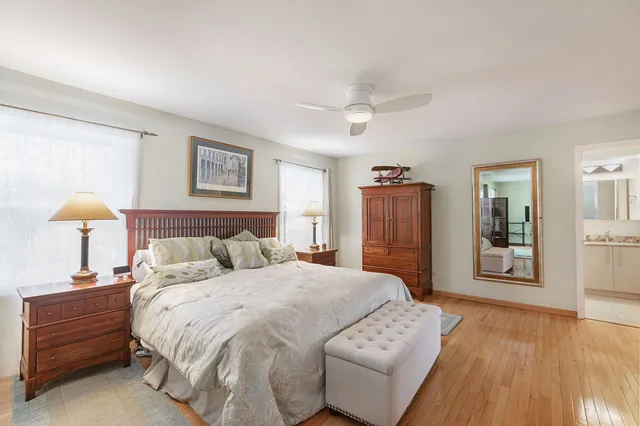 a spacious bedroom with a bed and wooden floor
