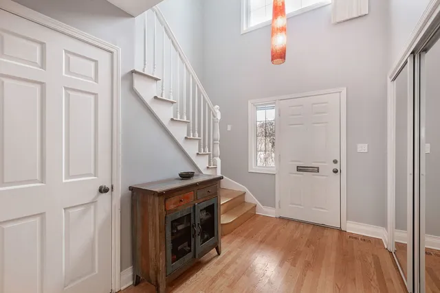 a view of a hallway with wooden floor and staircase