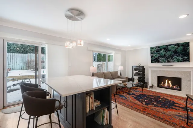 a living room with furniture a fireplace and a floor to ceiling window